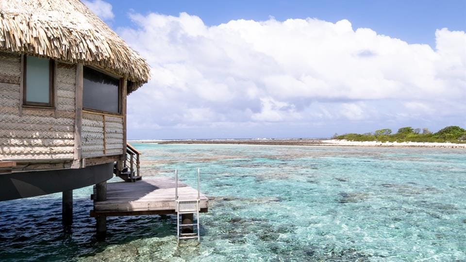 Overwater bungalow above turquoise lagoon, South Pacific
